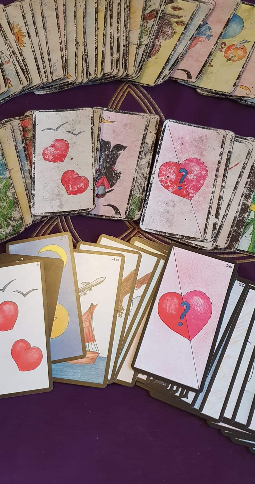 Cartes de l'Oracle Gé de Gérard Barbier utilisées en voyance sentimentale, disposées sur une nappe violette