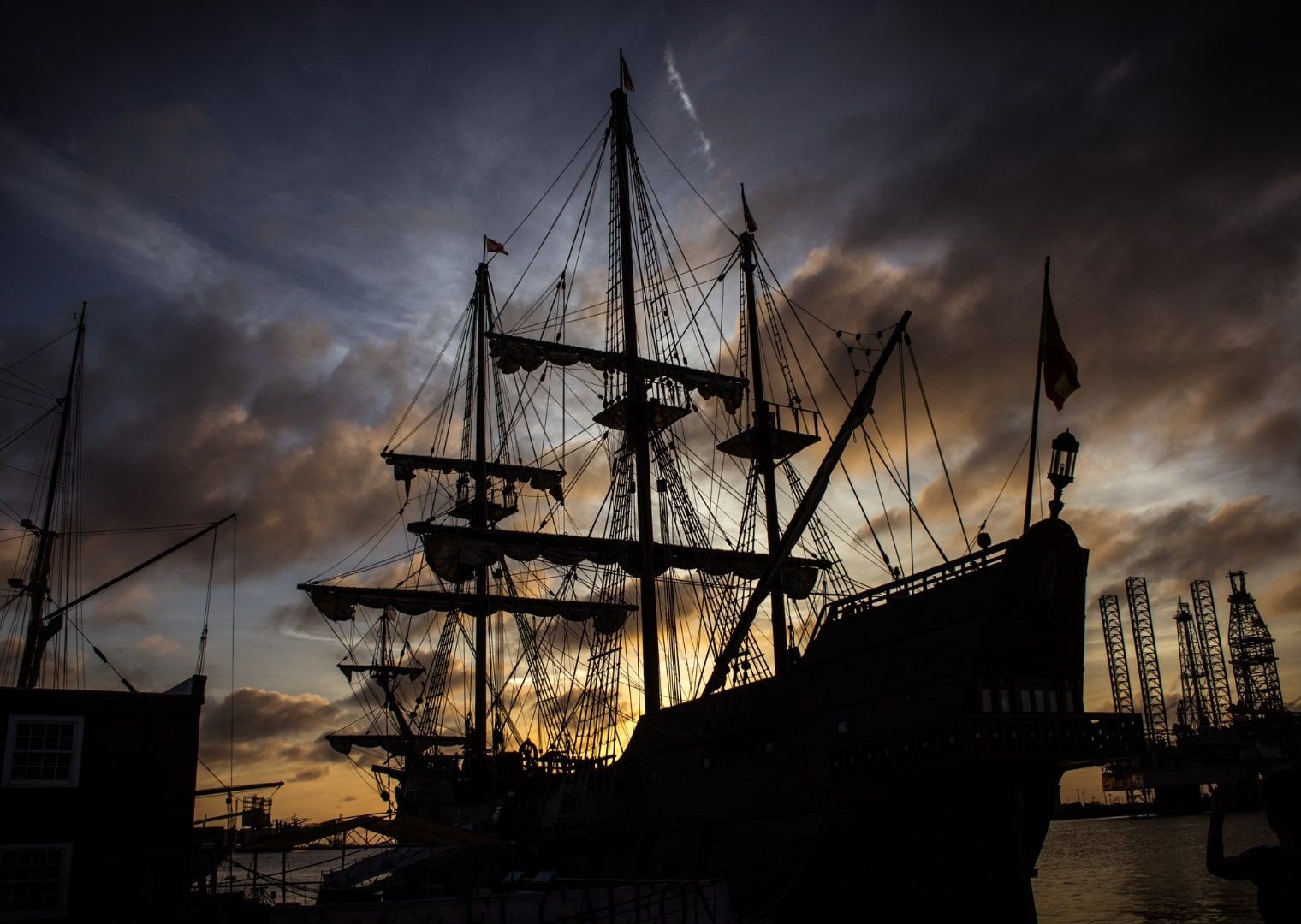 Silhouette d’un navire fantôme rappelant le Hollandais Volant au coucher du soleil.