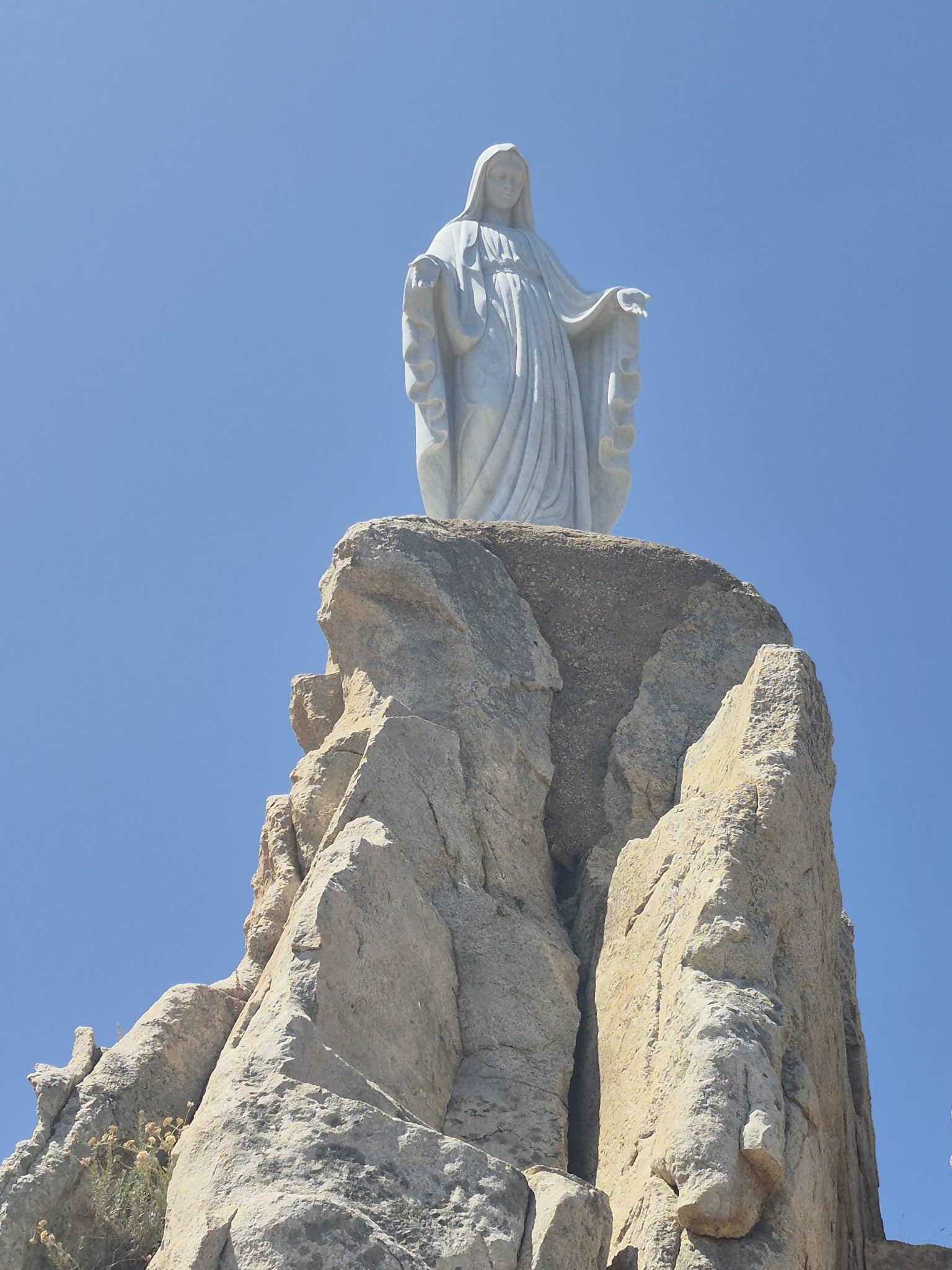 Statue de Notre-Dame de la Serra perchée sur un rocher à Calvi, Corse, photographiée lors d’une excursion en Balagne avec Kurnos Évasion depuis Bastia
