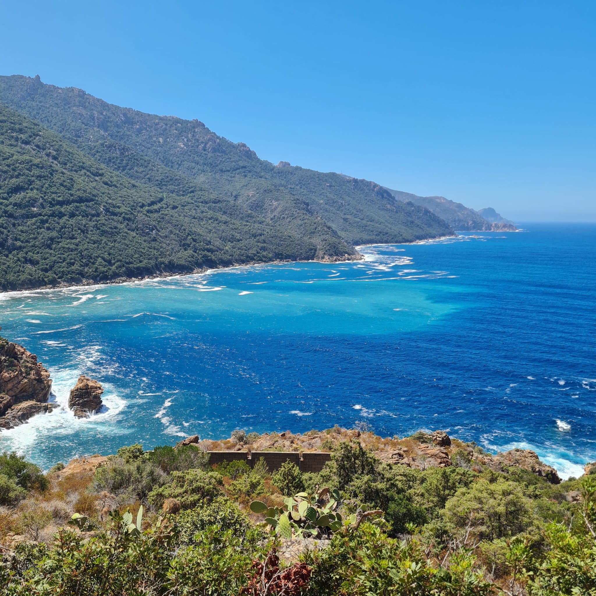 Côte rocheuse et mer turquoise du golfe de Porto en Corse, avec les montagnes du parc naturel régional, vue prise lors d’une excursion avec Kurnos Évasion